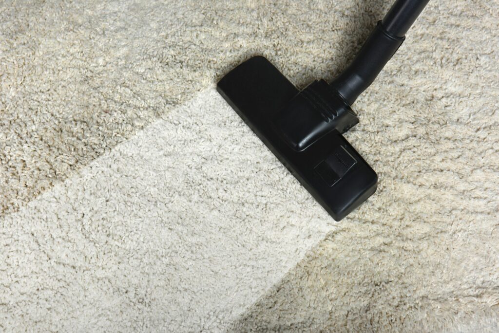 close-up view of cleaning white carpet with professional vacuum cleaner